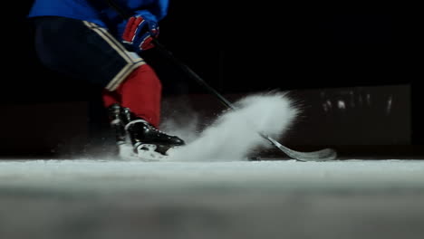 Nahaufnahme-Eines-Eishockey-Pucks-In-Zeitlupe-Und-Fliegendem-Schnee,-Der-Eishockeyspieler-Hebt-Den-Puck-Stick-Auf